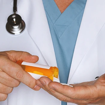 A doctor pouring a pill bottle on his hands