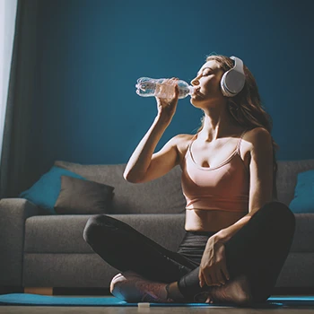 A woman doing yoga while drinking water