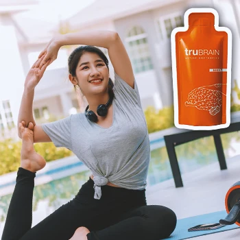 A woman doing yoga outside with TruBrain nootropic supplements on the side