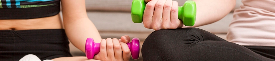 Two individuals holding their own dumbbells