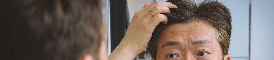 A man using nootropics checking his hair