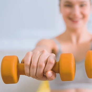 A woman holding dumbbells close to the camera