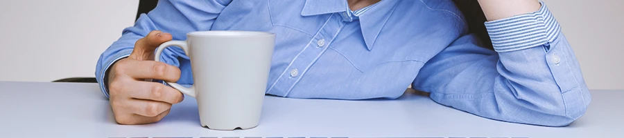 A woman holding coffee in an office