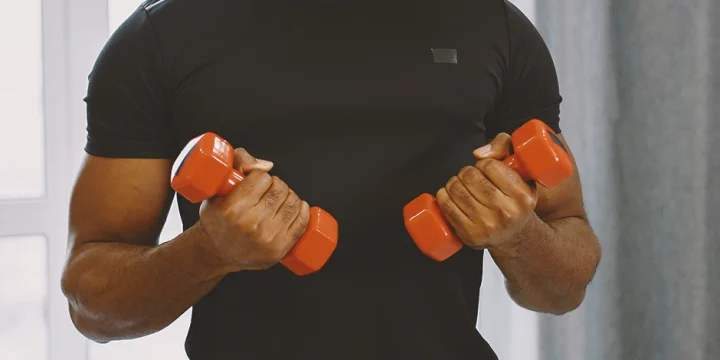 A man lifting dumbbells at his home gym
