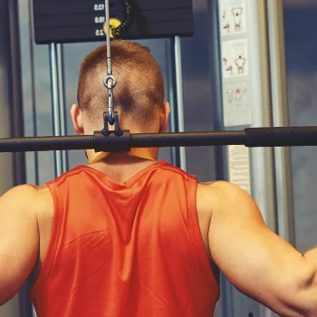 A man doing lat pulldowns in a home gym