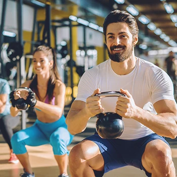 A man working out with other people in a commercial gym