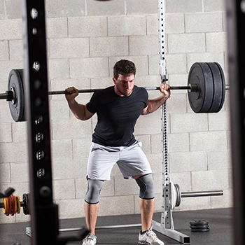 A man struggling to perform a barbell squat