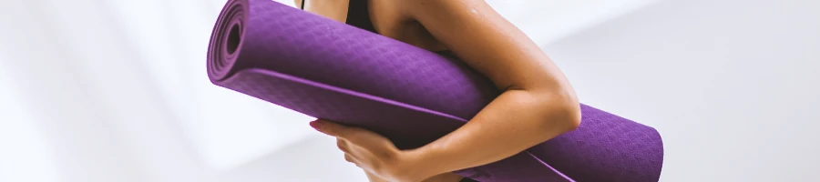 A woman holding a gym mat