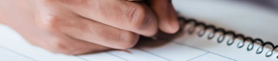 Close up shot of a person writing down notes in a gym