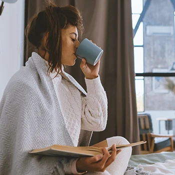 A woman drinking coffee with caffeine at home