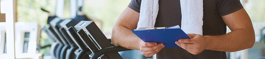 A coach with a clipboard planning a workout routine