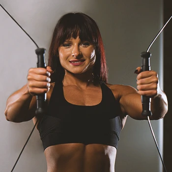 A woman working out on a cable machine in a home gym