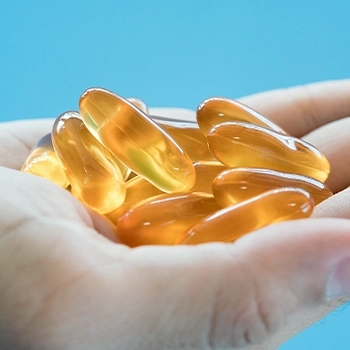 Holding a stack of omega-3 supplement pills