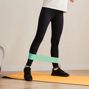 Woman doing side lunges with a resistance band