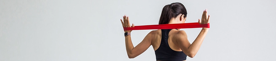 A woman performing upper body resistance band supersets