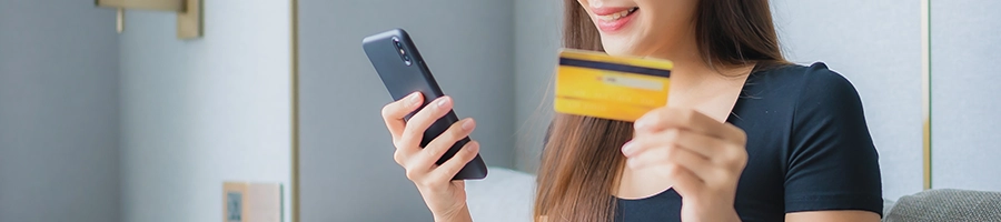 Woman buying supplement product online using her credit card and phone