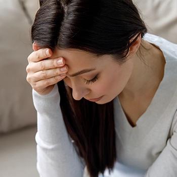 Woman having a headache from side effects