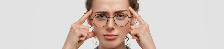 An intellectual woman wearing glasses pointing at her head