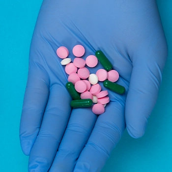 Top view of a professional with gloves holding pills