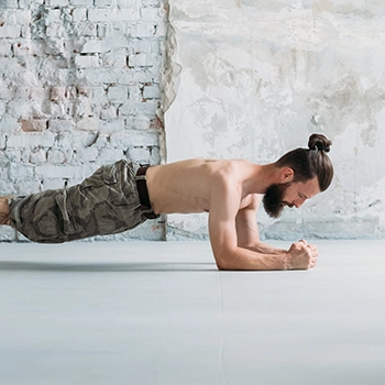 Man with a bun doing plank