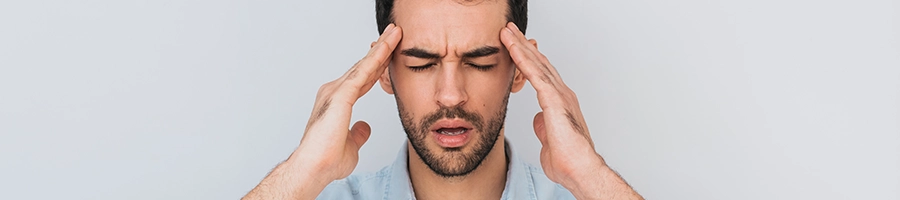 Man having headache while massaging head