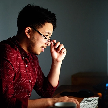 Man in glasses focused on his work online