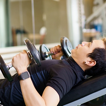 Holding two dumbbells while in an incline bench