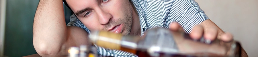 Drunk person pouring alcohol drink on his glass