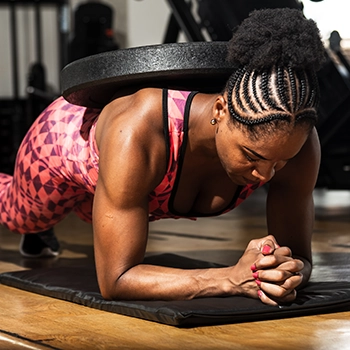 Doing a plank with a weight on her back