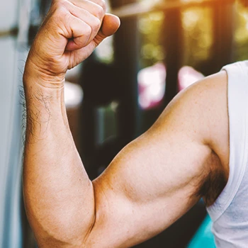 A person flexing his bicep close to the camera