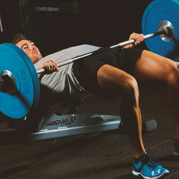 A man doing barbell hip thrusts