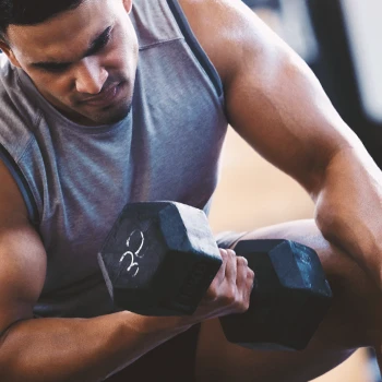 A buff man lifting weights with the help of C4 Ultimate Shred