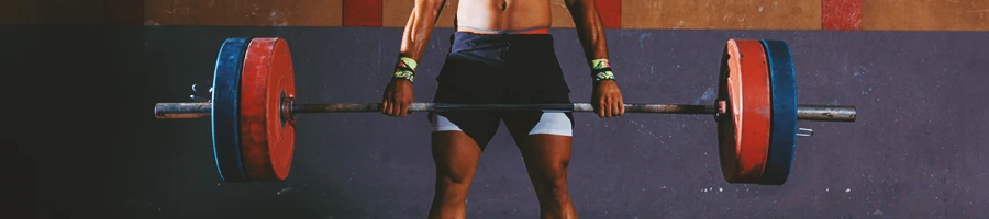 A man lifting a barbell in a gym