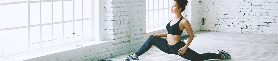 A woman doing a lunge stretch indoors