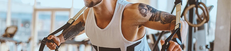 A buff man doing cable rear delt exercises