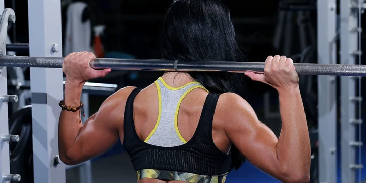 Woman holding barbell for back workouts