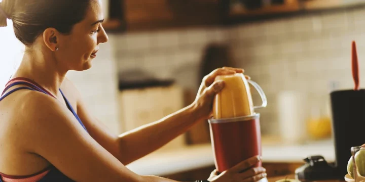 A woman making a meal replacement shake at home