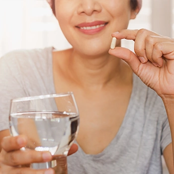 Woman holding a supplement pill