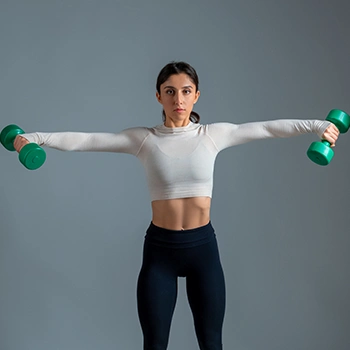 Woman using dumbbells doing lateral raises