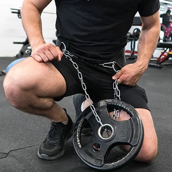 A man kneeling down while wearing a dip belt with weights