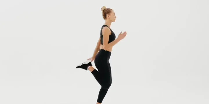 Performing Butt Kicks in plain background