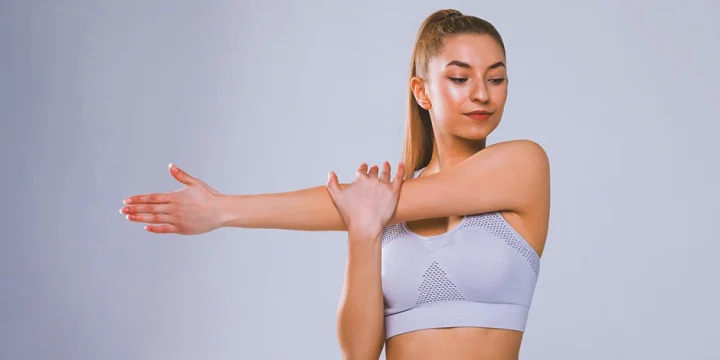 A woman stretching her real deltoids