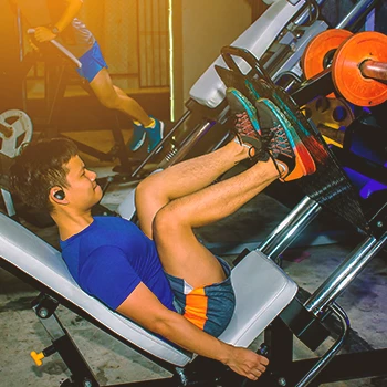 A buff male doing leg presses