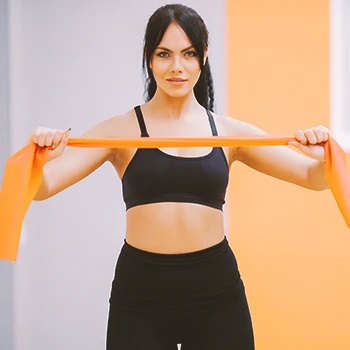 A woman pulling apart a resistance band for workout