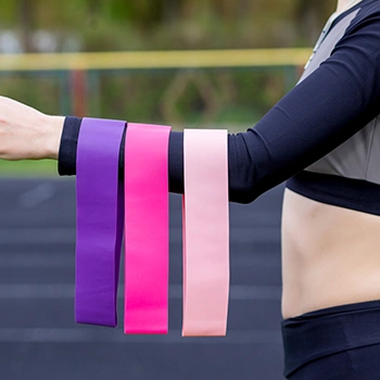 Three resistance band hanging from a person's hand