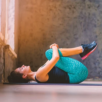 A woman doing the standard lying hip flexor stretch