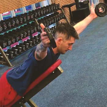 A person doing supine y raises in the gym