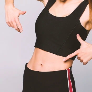 A woman pointing to her transverse abdominal muscles TVA