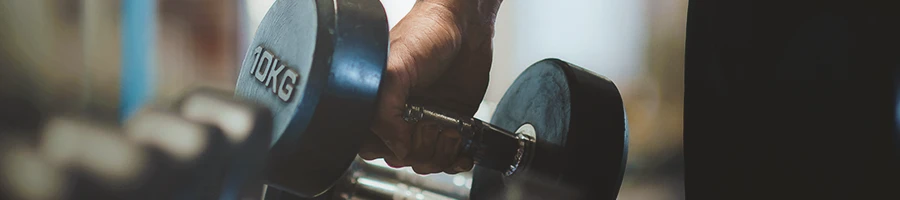 A person picking up a dumbbell in the gym