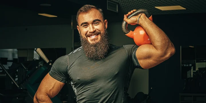Holding a kettlebell while smiling at the camera